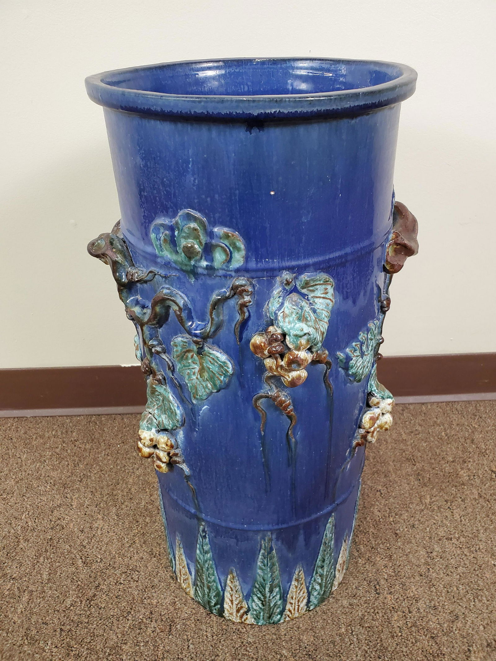 Pottery Umbrella Stand With Grapes: Glazed terra cotta. 13" wide X 10" deep X 22 1/2" high. Pottery has some cracks from when it was fired. Chips at base.