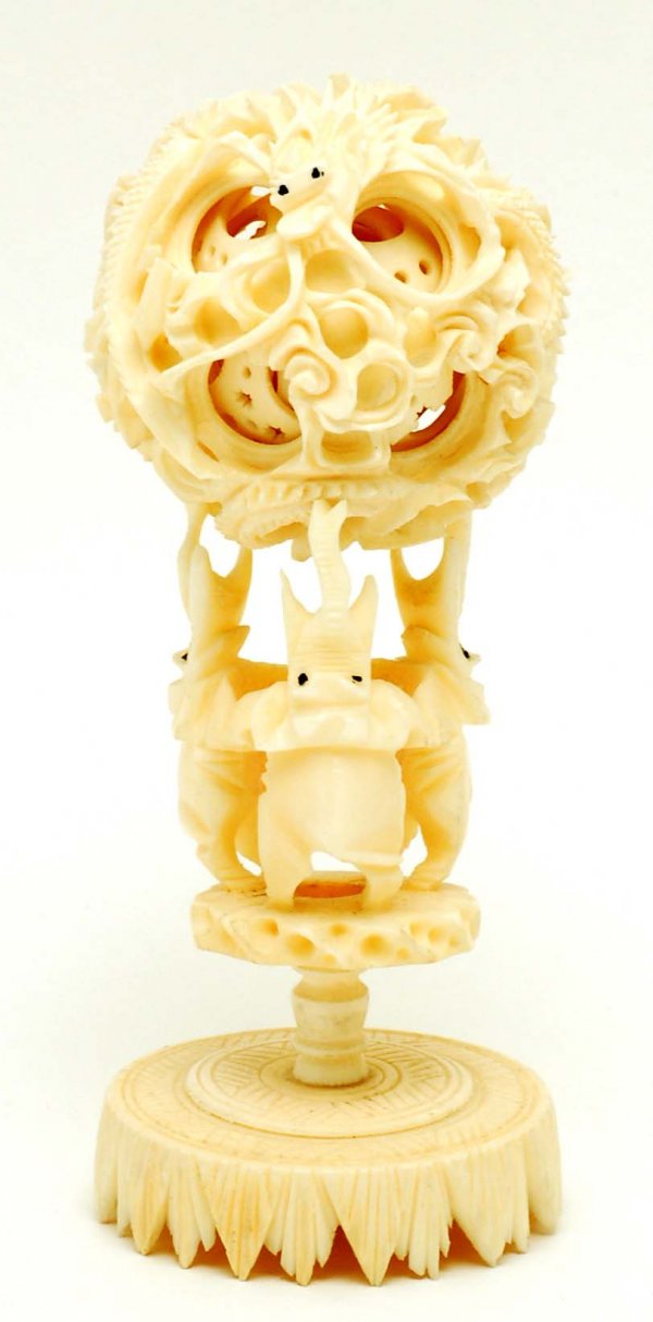 Chinese Carved Ivory Puzzle Ball on Stand: DESCRIPTION: A Chinese carved ivory puzzle ball. Outer most ball carved with two dragons. Supported on two piece stand of three upraised elephants on a round base. MEASUREMENTS: 2-1/4" diameter x 5". 