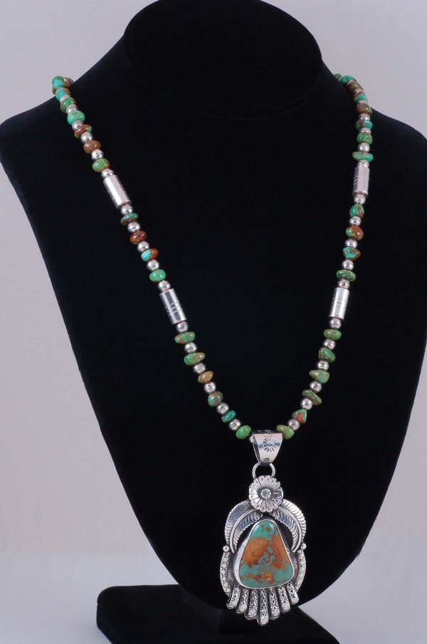 Signed Navajo Turquoise Pendant & Necklace: DESCRIPTION: A Navajo pendant and necklace in marked sterling and turquoise. Pendant having flower and feather design and set with a large turquoise stone. Signed "JR". Necklace of alternating sterlin