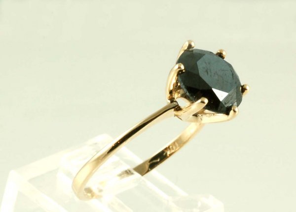 2.5 Carat Black Diamond Solitaire Ring: DESCRIPTION: Black diamond solitaire ring in marked 10K yellow gold. One round brilliant cut black diamond. 2.5 ctw. Size 7. 1.4 dwt (2.1 grams). Appraised value $2,425.00 (appraisal included).