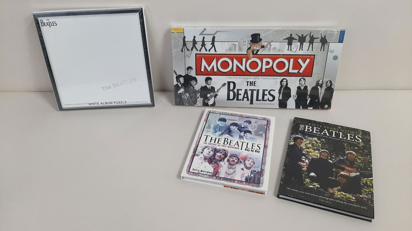 4 Pcs Beatles incl. Monopoly: Also includes White Album jigsaw puzzle, The Beatles Day by Day by Terry Burrows, and Fifty Years with the Beatles by Tim Hill. Monopoly and puzzle both unopened.