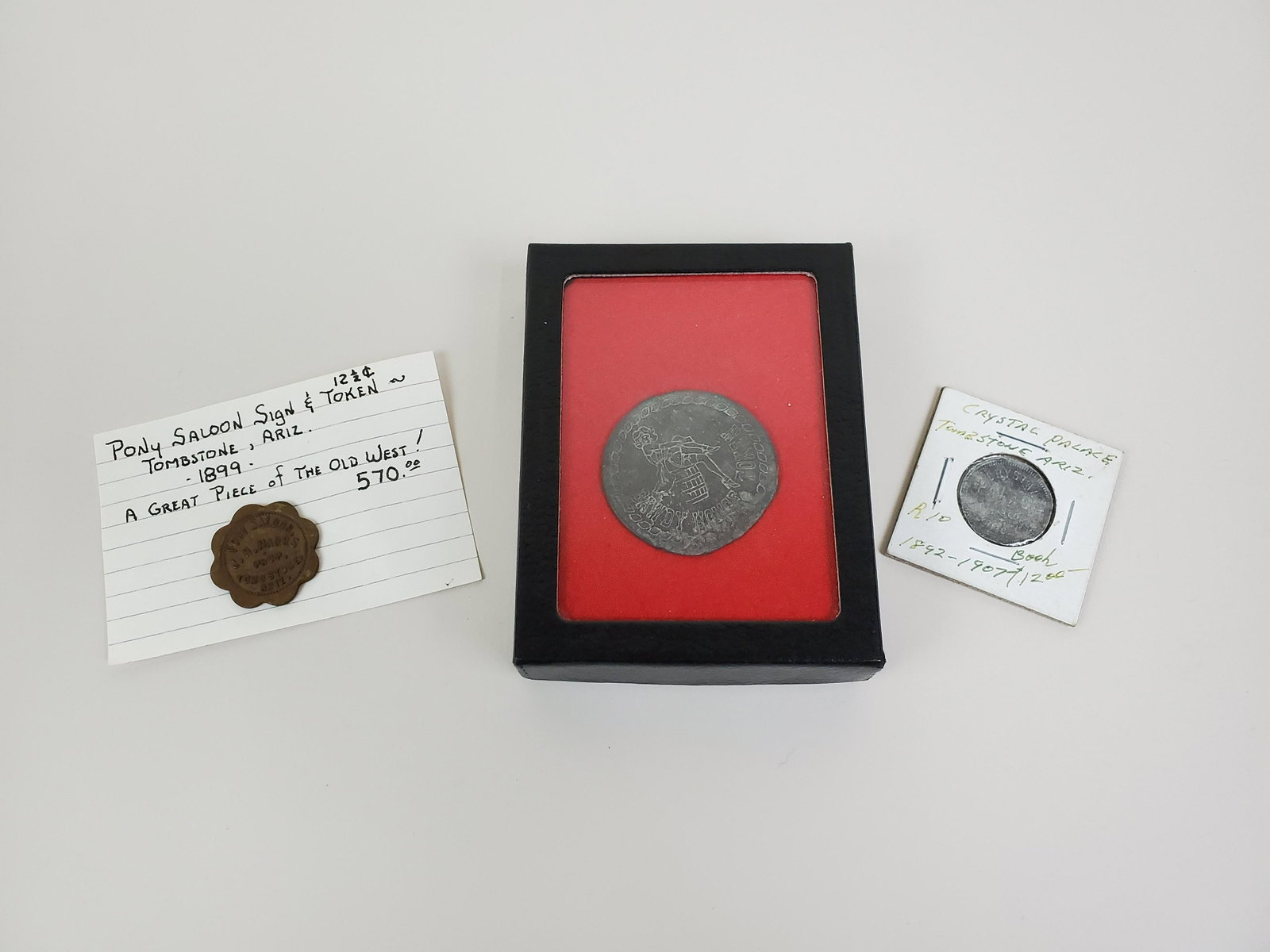 2 Tombstone Tokens & Old West Brothel Token: Some wear. From the Estate Collection of Stephen R. Reed.