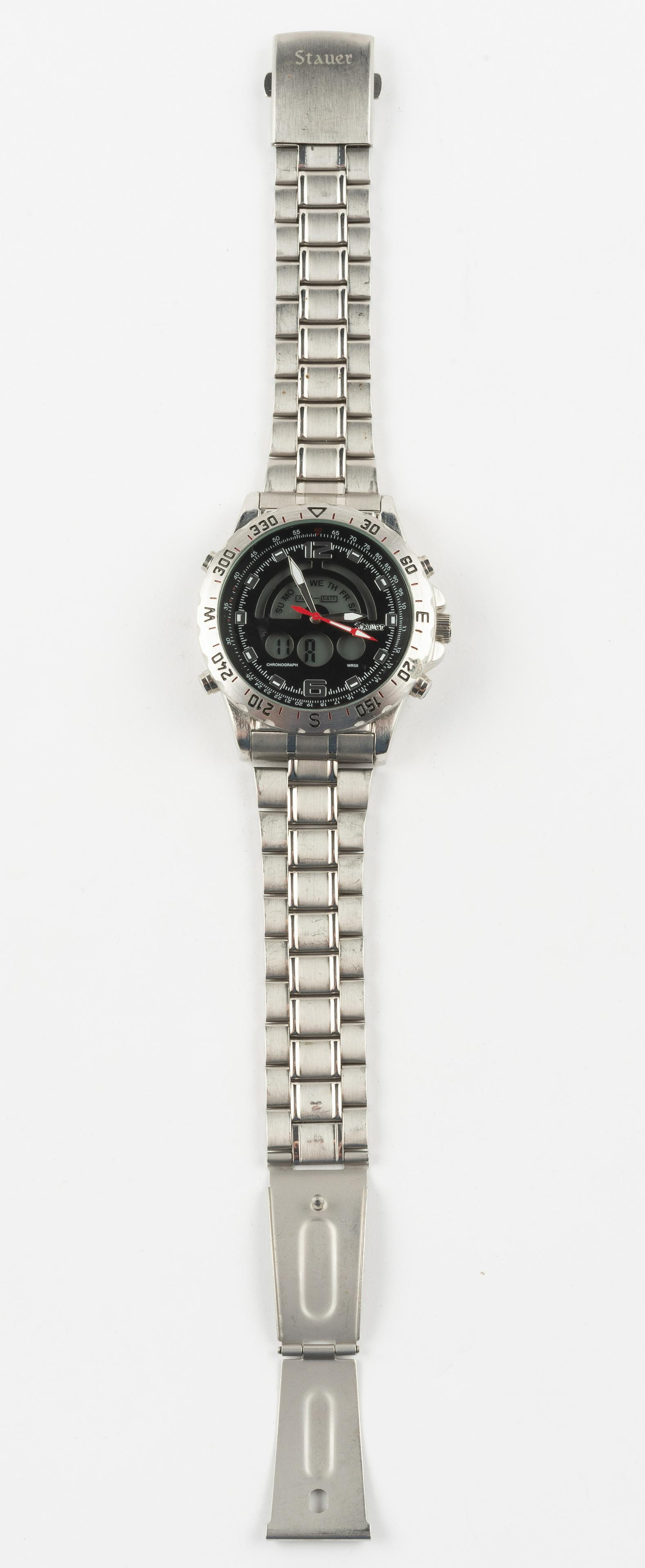 Stauer Men's Wristwatch: Model 19093. Stainless Steel Case Back. 2" lug to lug. 8-1/2" band. Missing one spring bar. IMPORTANT: Before bidding, please read the terms and conditions. When you registered for the auction you agr