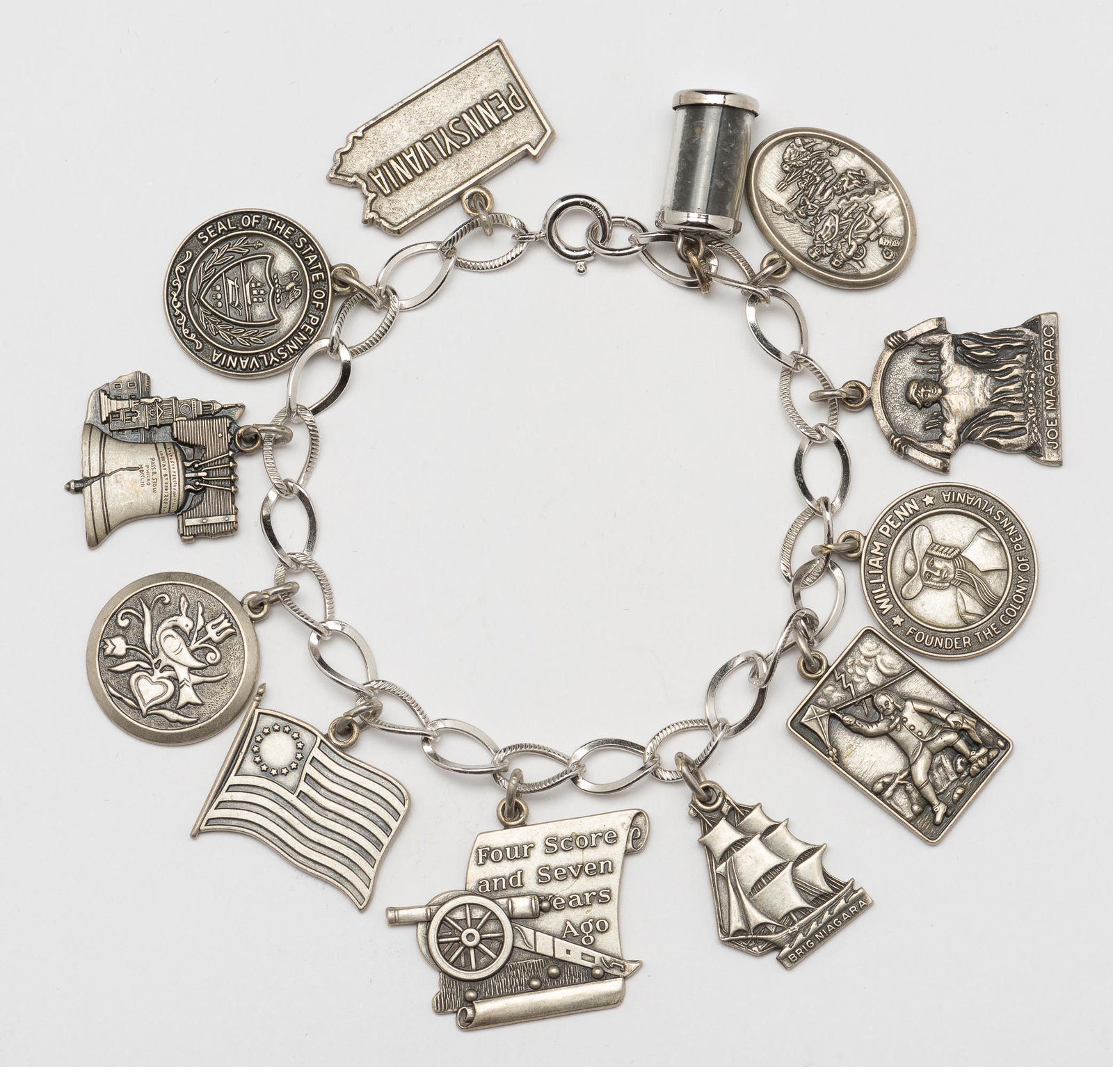Sterling Charm Bracelet with 12 Charms: 8" long. IMPORTANT: Before bidding, please read the terms and conditions. When you registered for the auction you agreed to these terms and will be required to comply with them.