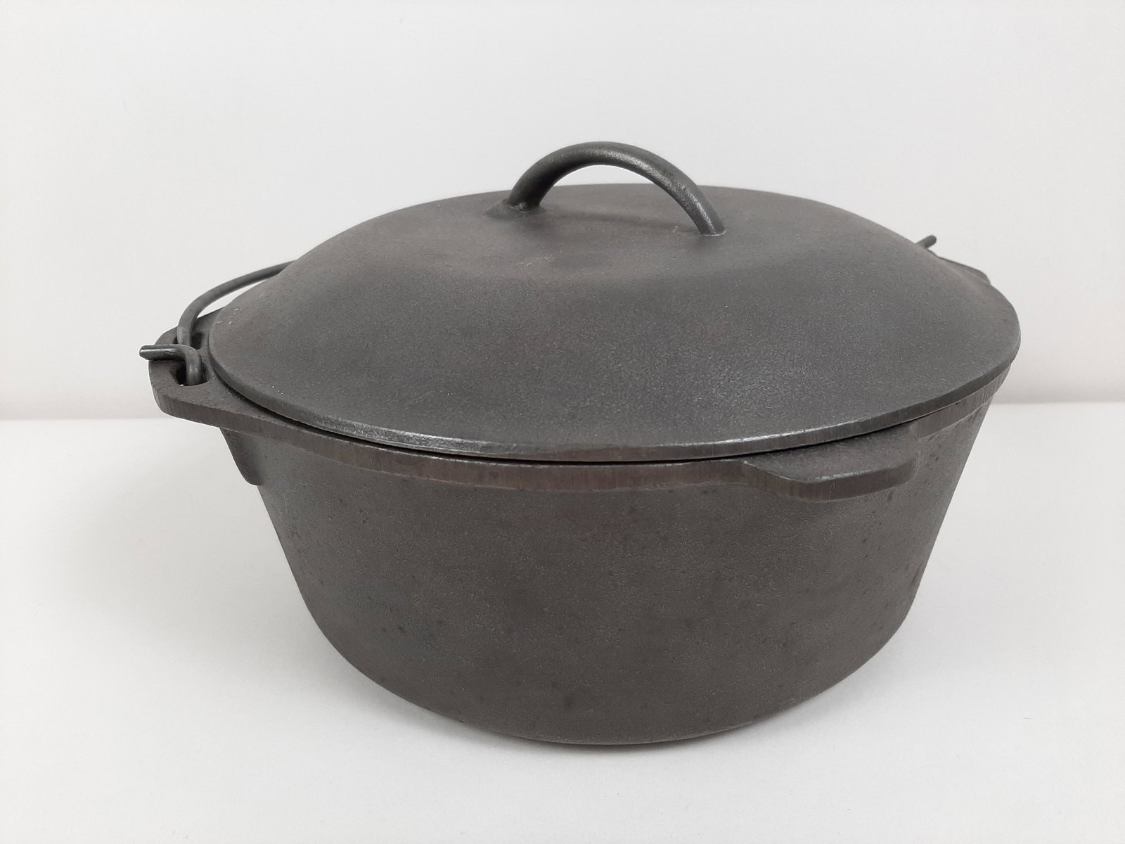 Cast Iron Dutch Oven: Size 8. No maker's mark. IMPORTANT: Before bidding, please read the terms and conditions. When you registered for the auction you agreed to these terms and will be required to comply with them.