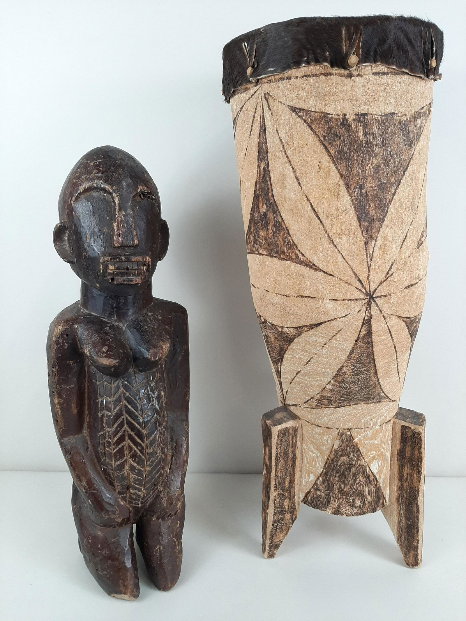 African Carved Figure and Drum: 22" to 26¾" high. IMPORTANT: Before bidding, please read the terms and conditions. When you registered for the auction you agreed to these terms and will be required to comply with them.