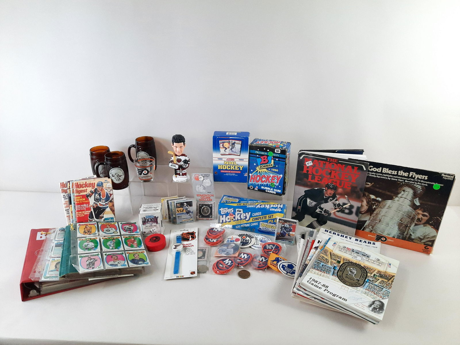 Large Collection of Hockey Memorabilia: Includes programs, patches, tokens, cards, mugs and bobble head. IMPORTANT: Before bidding, please read the terms and conditions. When you registered for the auction you agreed to these terms and will