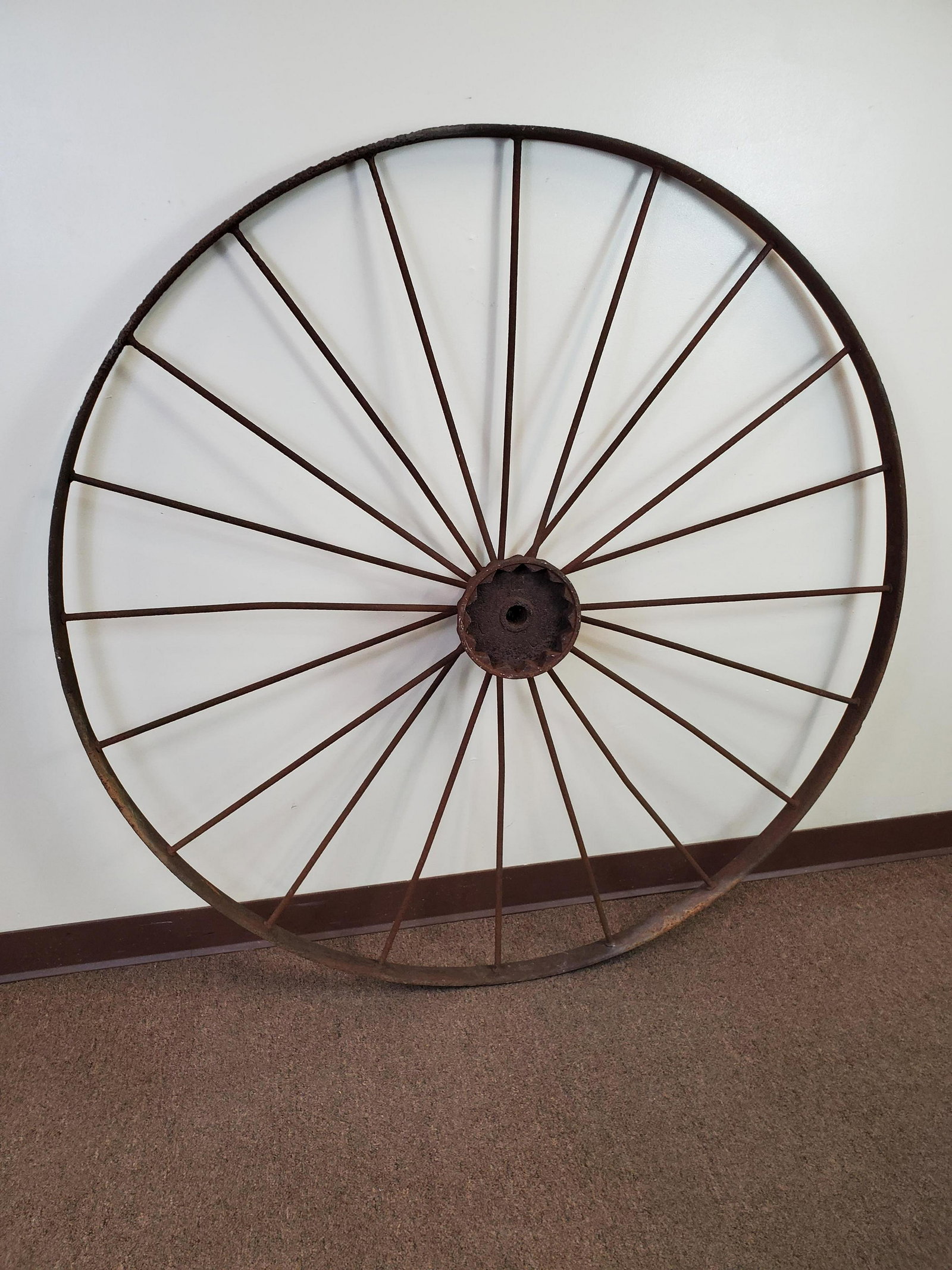 Antique Iron Carriage Wheel: 54" diameter. Has rust and pitting. IMPORTANT: Before bidding, please read the terms and conditions. When you registered for the auction you agreed to these terms and will be required to comply with t