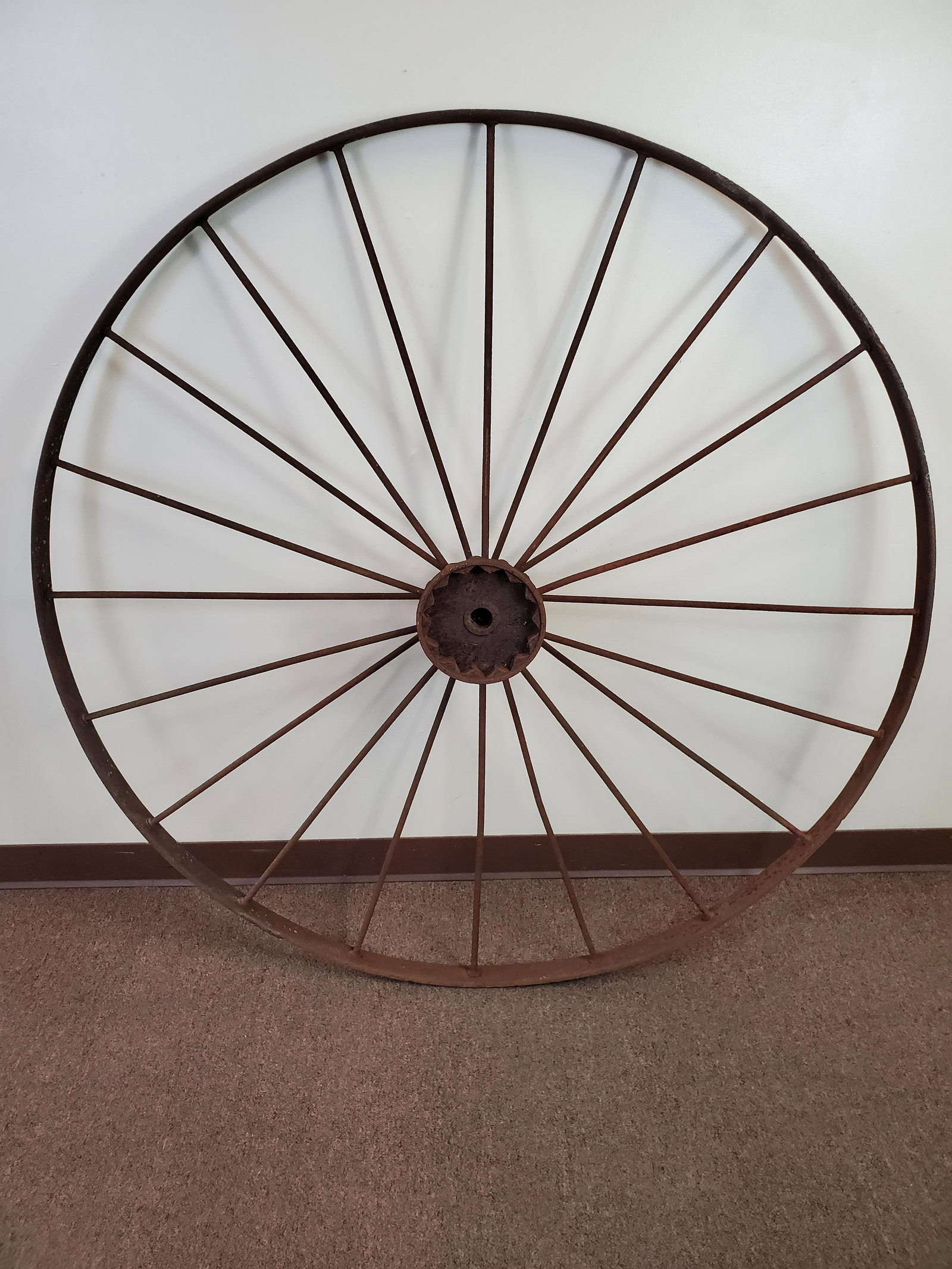 Antique Iron Carriage Wheel: 54" diameter. Has rust and pitting. IMPORTANT: Before bidding, please read the terms and conditions. When you registered for the auction you agreed to these terms and will be required to comply with t