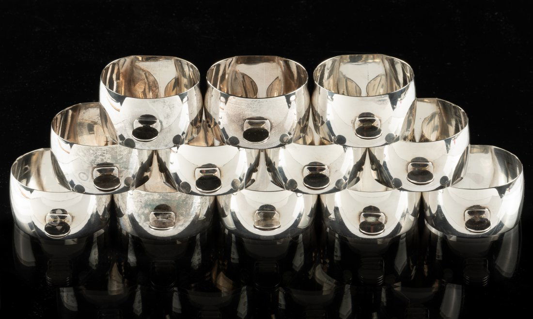 12 Sterling Napkin Rings: No maker's mark. Each in wooden box. 6.4 ozt. 1 5/8" diameter x 1" high. IMPORTANT: Before bidding, please read the terms and conditions. When you registered for the auction you agreed to these terms