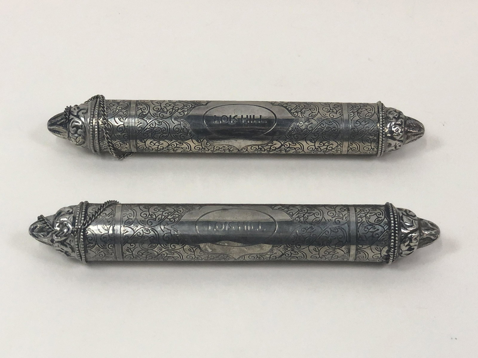 Silver Invitation Holders: Silver tubes would hold invitations to a reception in Santa Ana CA to reveal Lois Hill's "Passage to India" jewelry line. Similar tubes are apparently used to carry wedding invitations in India. 10 1/