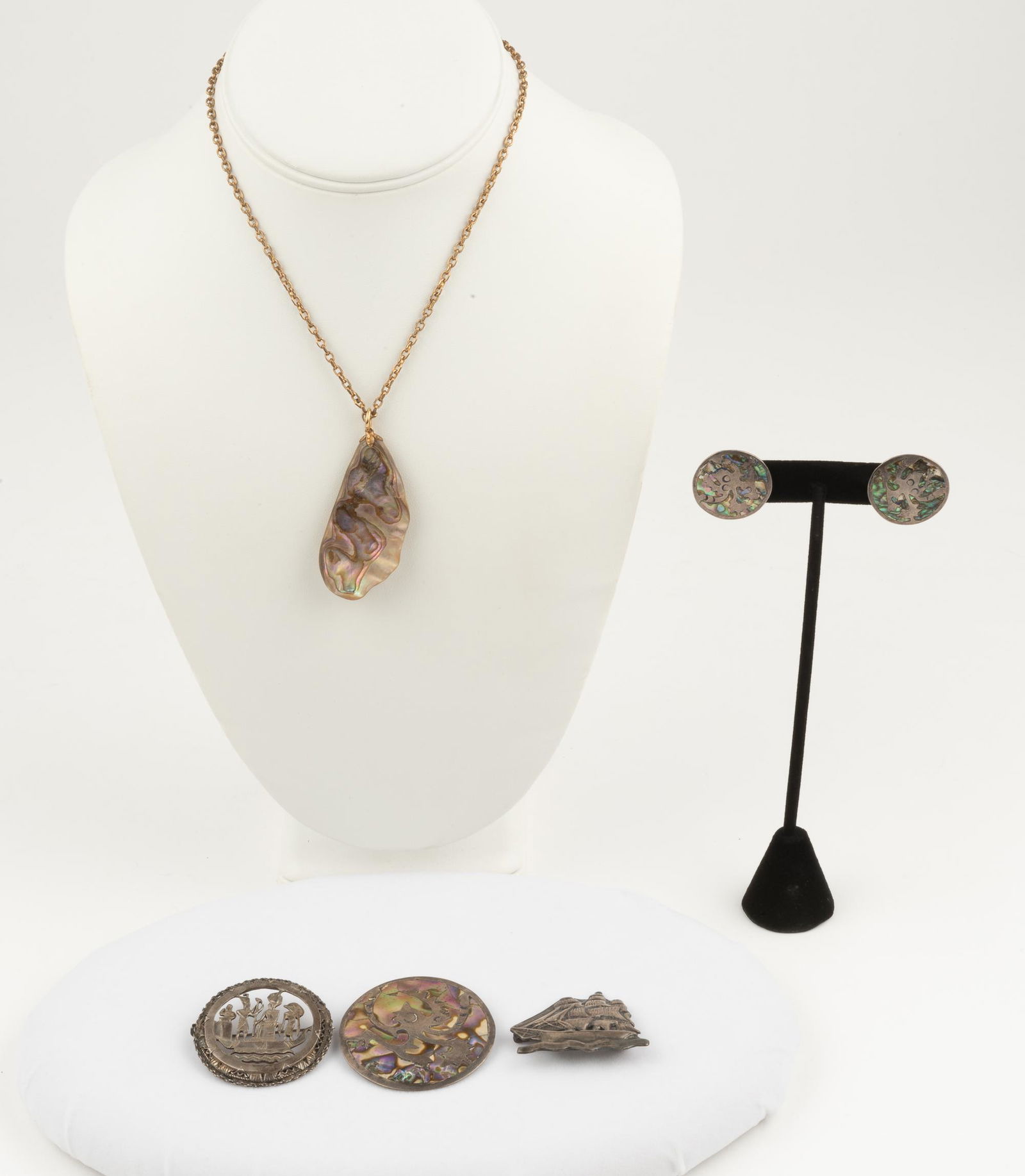 5 Pcs Jewelry Incl. Sterling & Abalone: Taxco silver & abalone pin and earrings; earrings 1" diameter, pin 1 3/4" diameter. Raw abalone pendant 2" long on 15" gold filled chain. Neoclassical Egyptian pin 1 1/2" diameter. Sterling ship pin 1