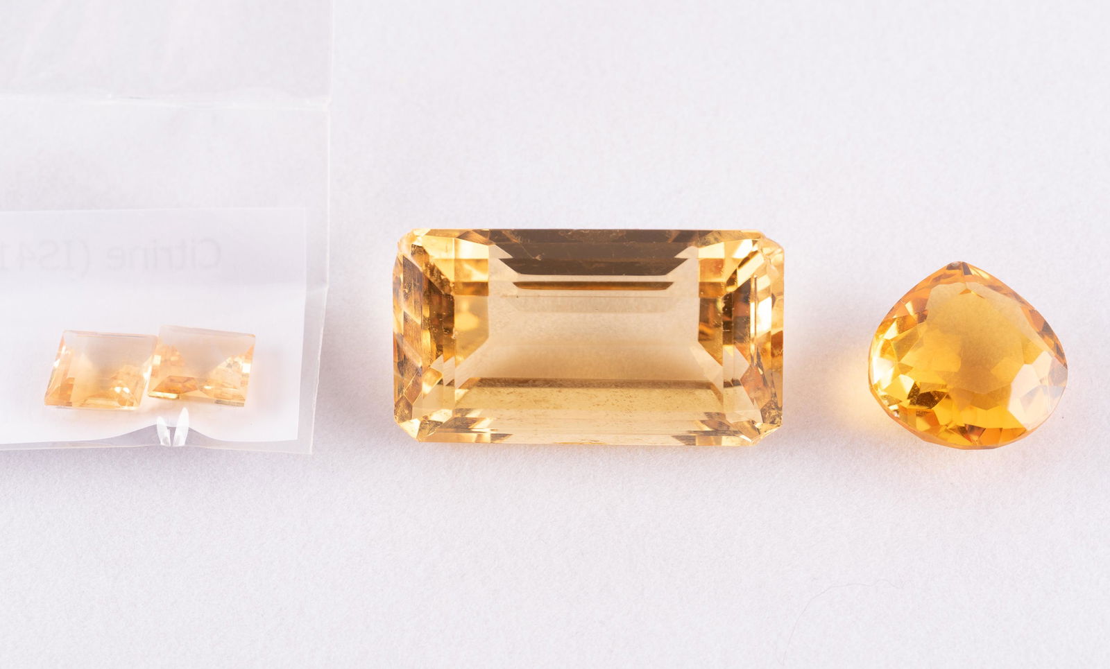 4 Citrine: Two square cut, 4.06 ctw. One pear cut, 13.5 carats with GGL certificate. One emerald cut, 52 carats, glue residue to back. IMPORTANT: Before bidding, please read the terms and conditions. When you re