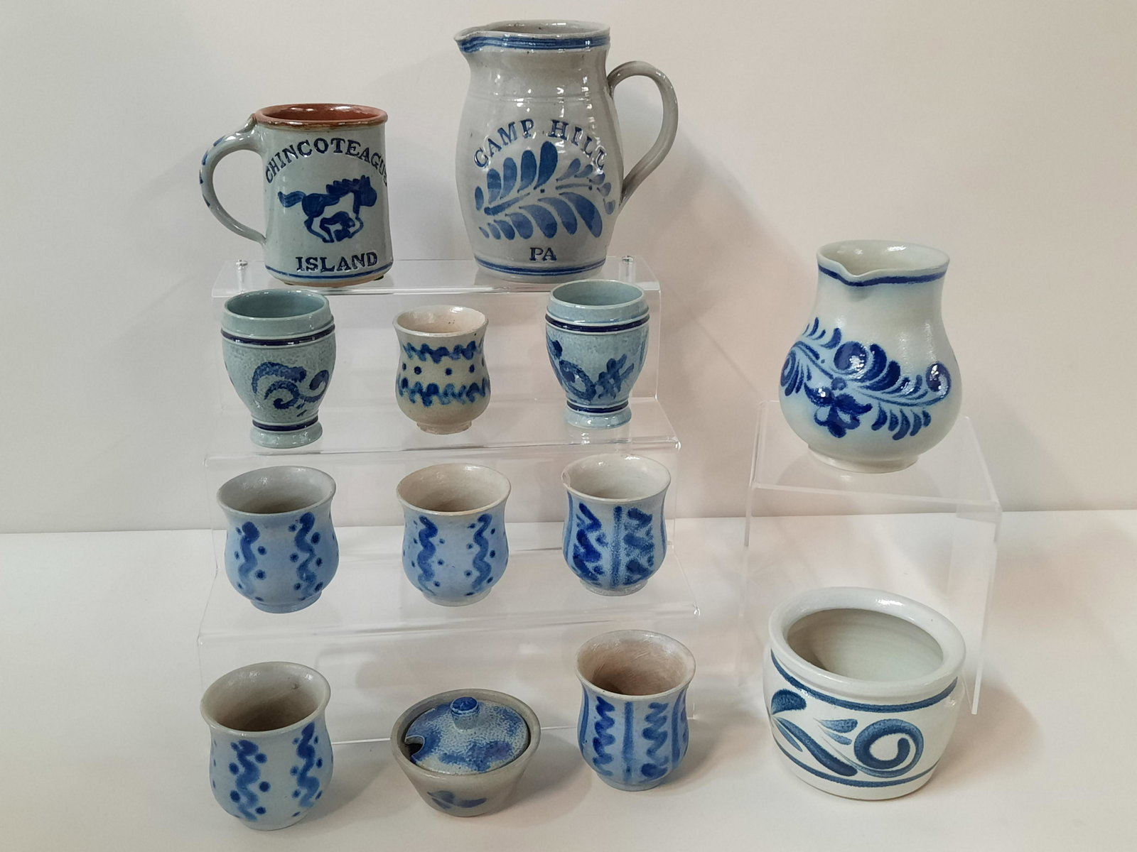 13 Pcs Stoneware incl Goebel: Also includes Camp Hill, PA pitcher and Chincoteague Island mug. 2-1/4" to 6-1/2" high. IMPORTANT: Before bidding, please read the terms and conditions. When you registered for the auction you agreed