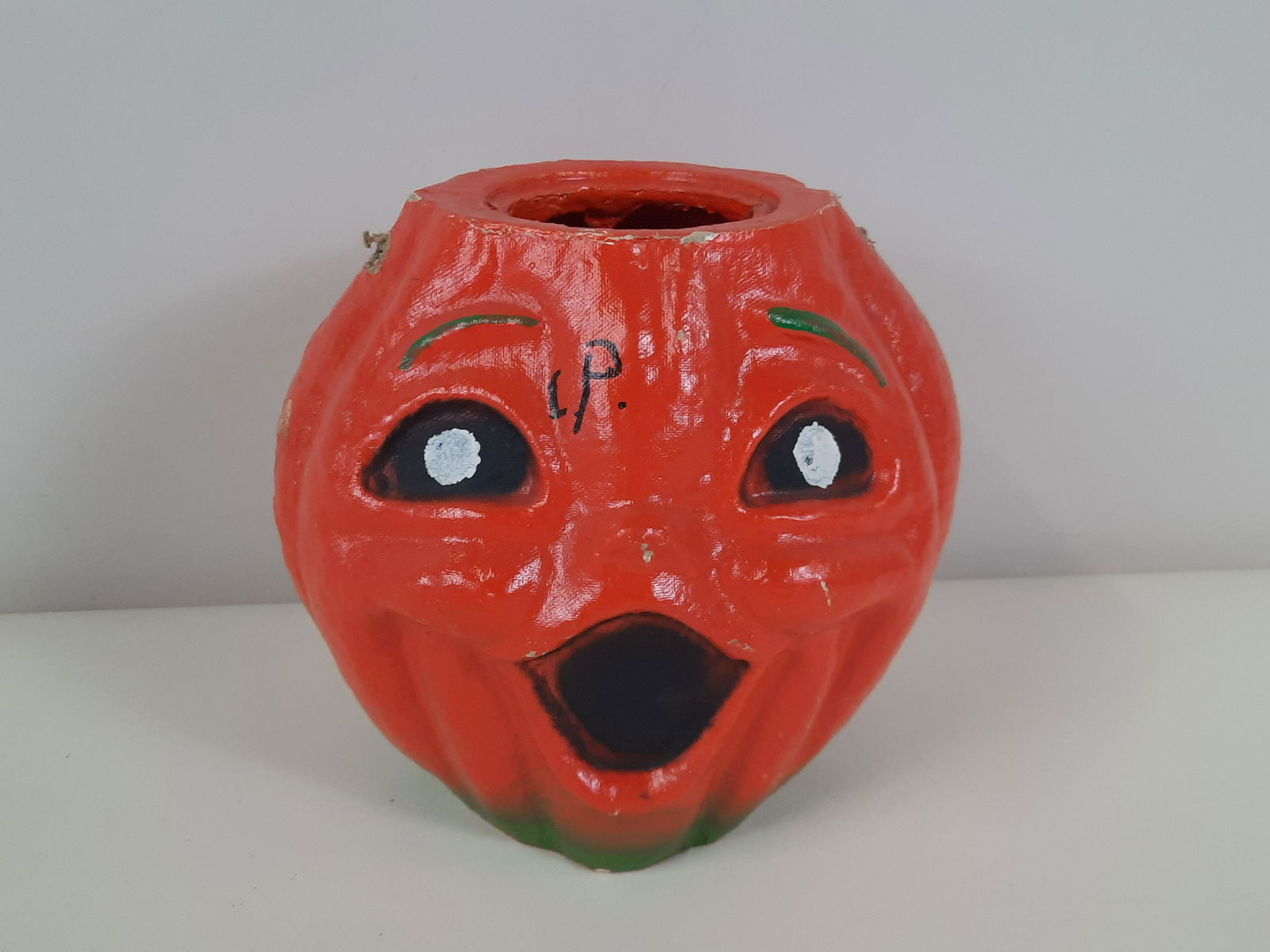 Vintage Paper Mache Pumpkin: 8" wide x 7-1/2" high. Marking on face. Some finish losses. Missing handle. IMPORTANT: Before bidding, please read the terms and conditions. When you registered for the auction you agreed to these ter