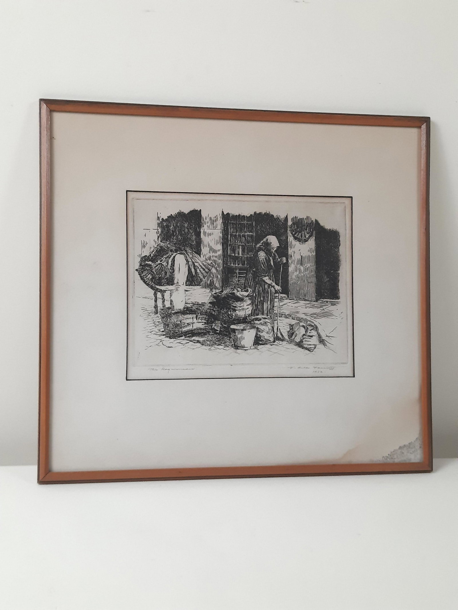 Signed "The Rag Woman" Print: Signature indecipherable. Dated 1932. Overall with frame 13-1/4" high x 14-1/4" wide. IMPORTANT: Before bidding, please read the terms and conditions. When you registered for the auction you agreed to