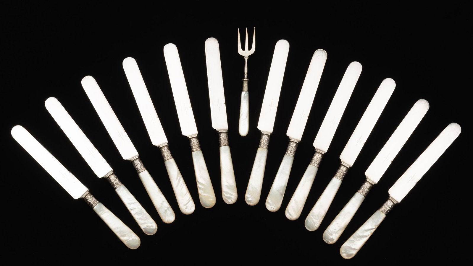 13 Mother of Pearl Handled Utensils: 12 knives, marked 1894 J. Russell & CO to blades, 9-1/8" long. Fork 6 1/4" long. IMPORTANT: Before bidding, please read the terms and conditions. When you registered for the auction you agreed to thes