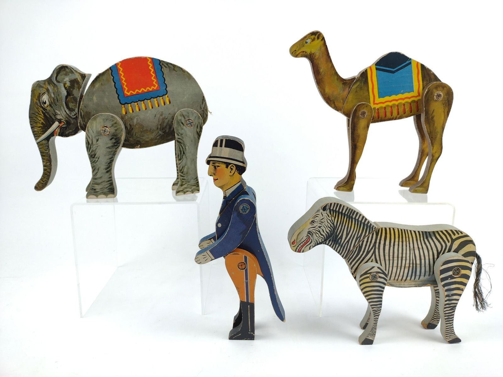 4 Vintage Paper on Wood Circus Toys: 7" to 9-3/8" high x 3" to 9-1/2" wide. Elephant missing tail. IMPORTANT: Before bidding, please read the terms and conditions. When you registered for the auction you agreed to these terms and will be