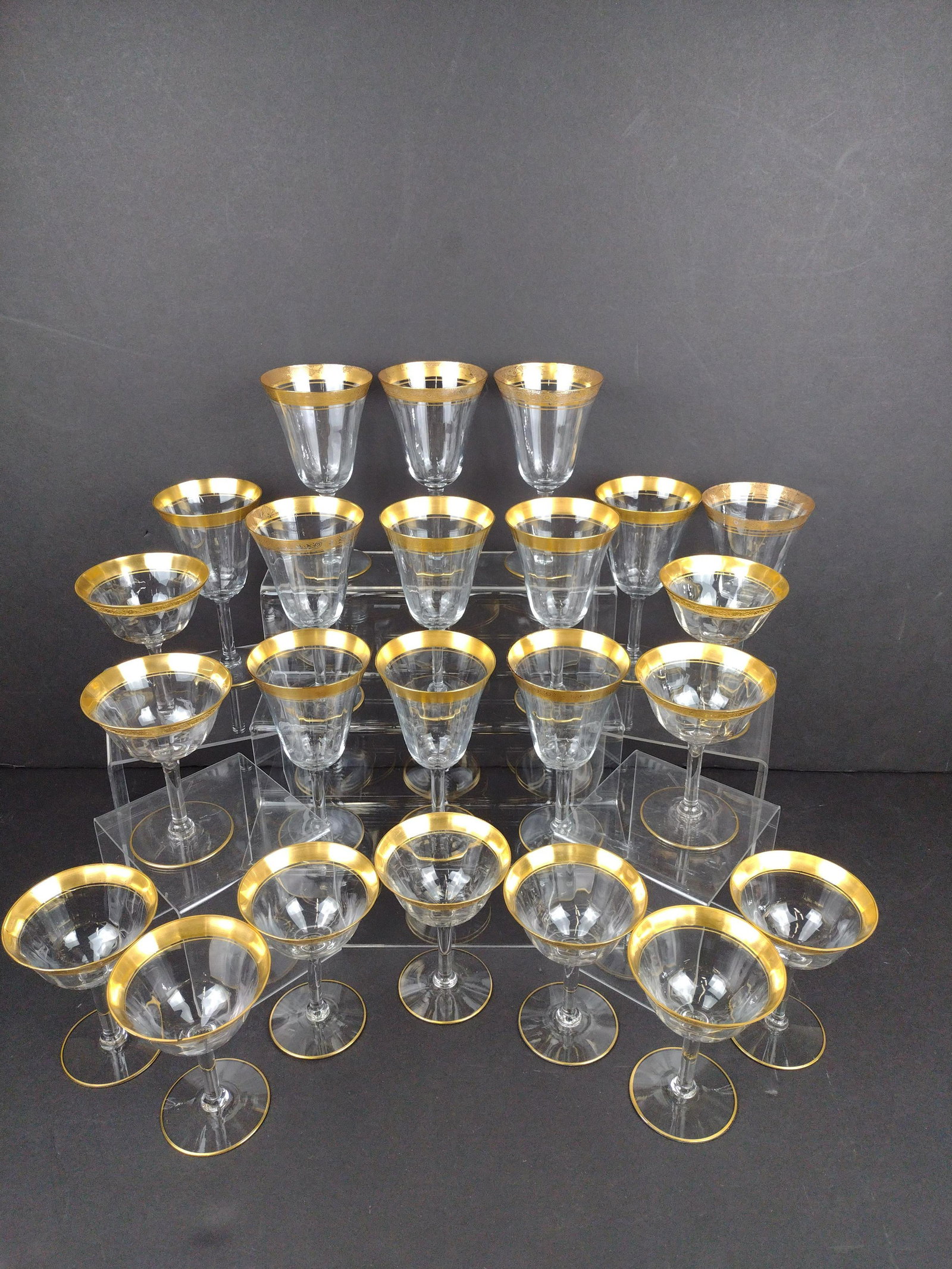 23 Gold Rimmed Wine Glasses: Eleven 5" high glasses and twelve 6-3/4" high glasses. IMPORTANT: Before bidding, please read the terms and conditions. When you registered for the auction you agreed to these terms and will be requir