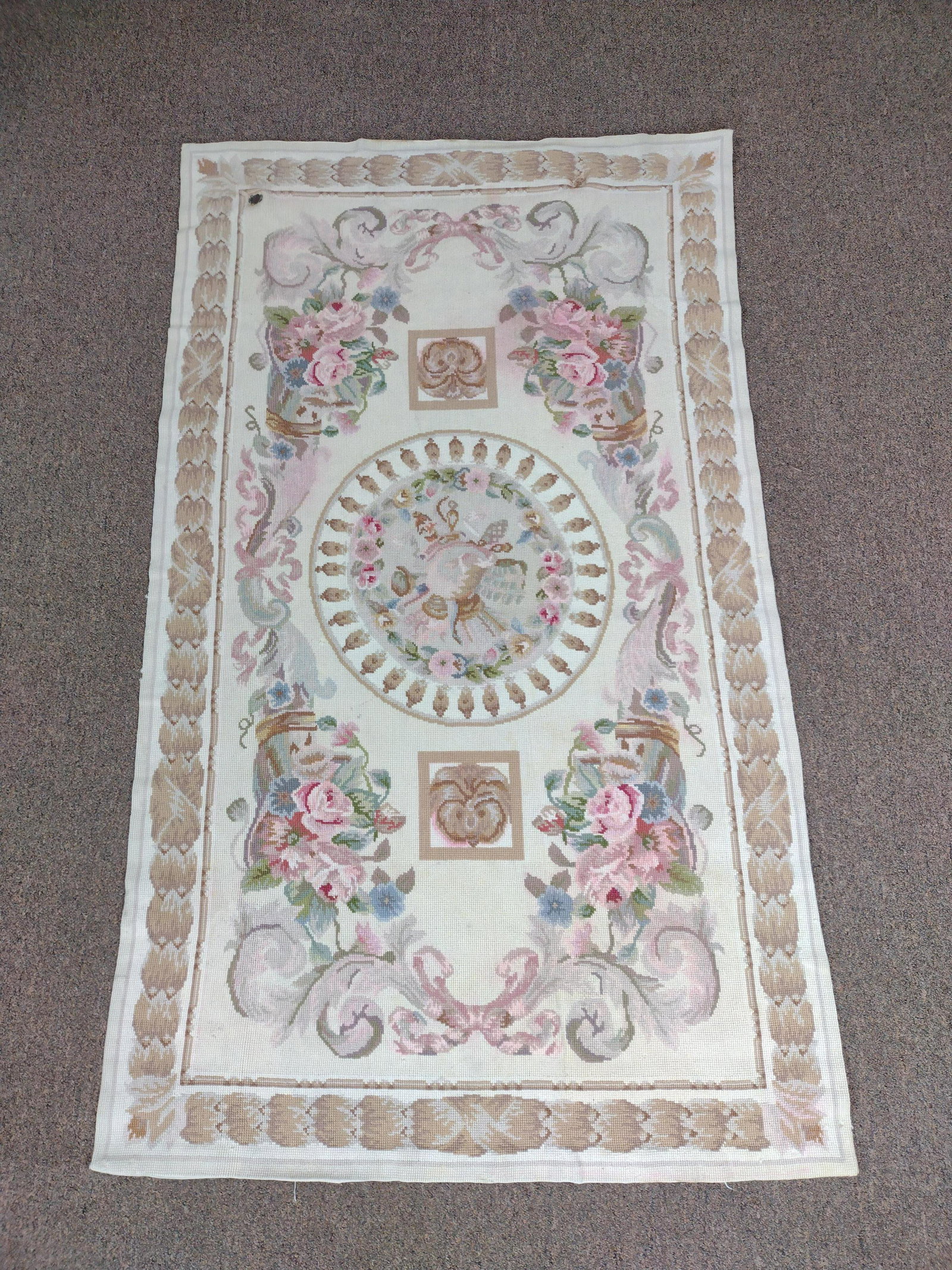 Hand Knotted and Embroidered Wool Area Rug: Central medallion with floral design in pink, green, and blue on cream ground. Mid 20th century. 32" wide x 54" long. IMPORTANT: Before bidding, please read the terms and conditions. When you register