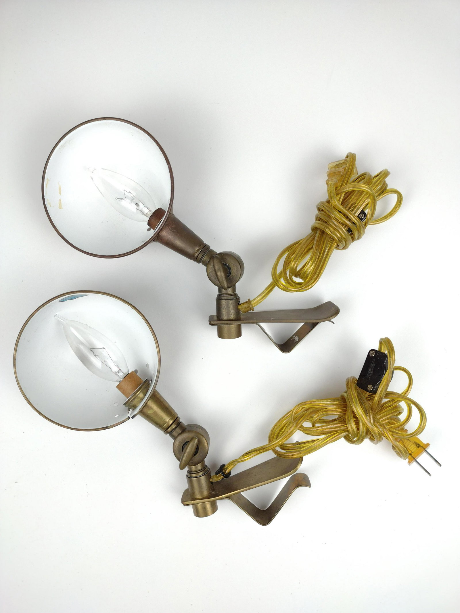 2 Antique Clip-On Lamps: Brass. Adjustable height. Working. Clips 4-1/2" long. Shade to one broken. IMPORTANT: Before bidding, please read the terms and conditions. When you registered for the auction you agreed to these term