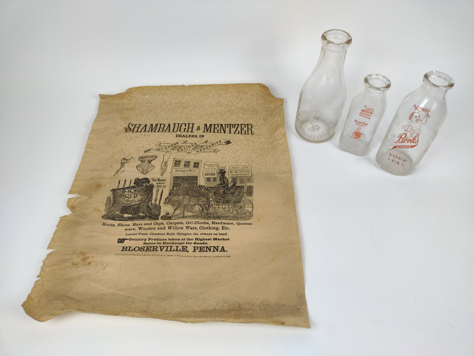 4 Pcs Advertising Bottles and Broadside: Includes broadside for Shambaugh & Mentzer, Bloserville PA. Also includes Beck's, Strohm's, and Miller-Reed milk bottles. Broadside: 18" wide X 23" high. Bottles: 7" to 9-1/2" high. IMPORTANT: Before 