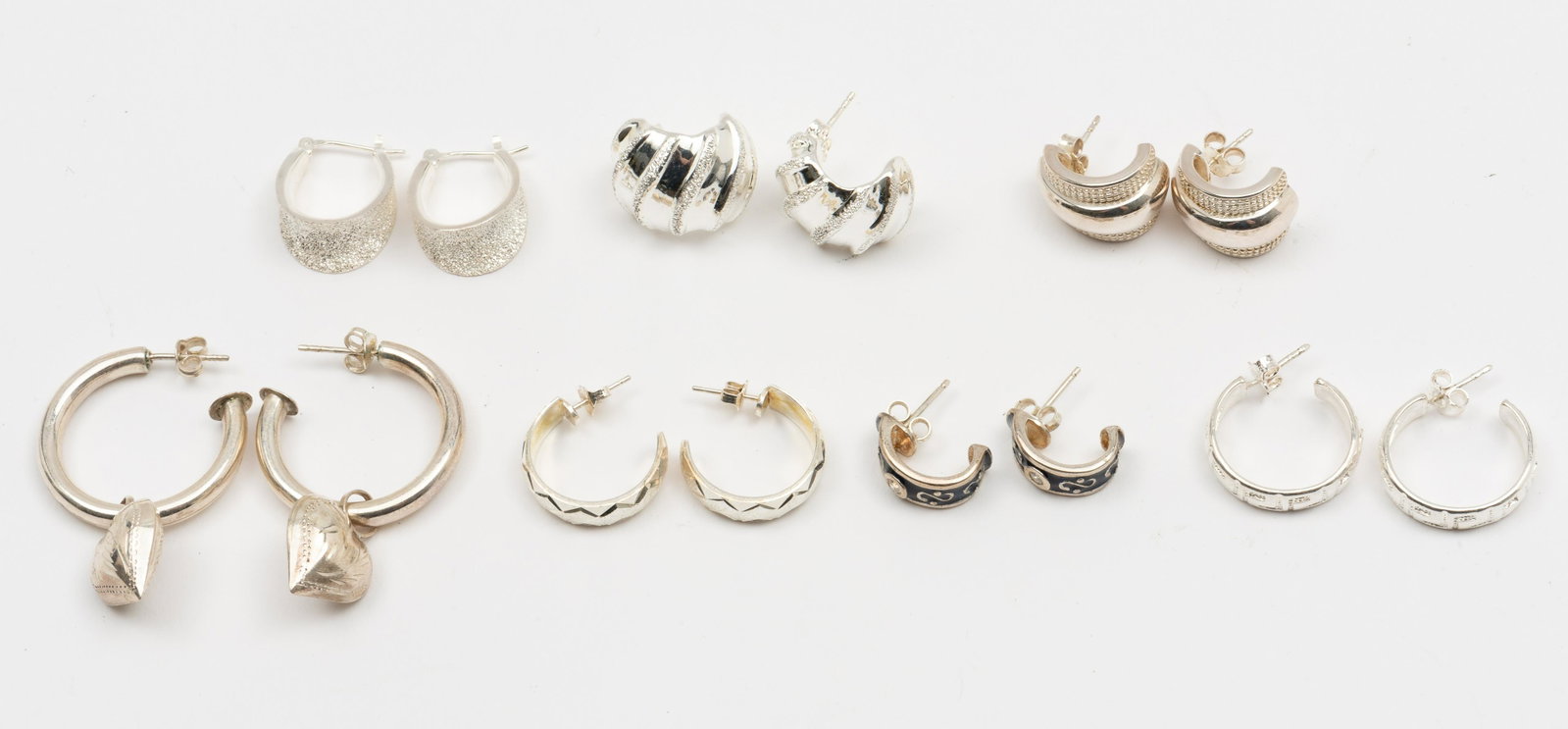7 Pairs Sterling Hoop Earrings: All pierced. 3/4" to 1-3/4" long. IMPORTANT: Before bidding, please read the terms and conditions. When you registered for the auction you agreed to these terms and will be required to comply with the
