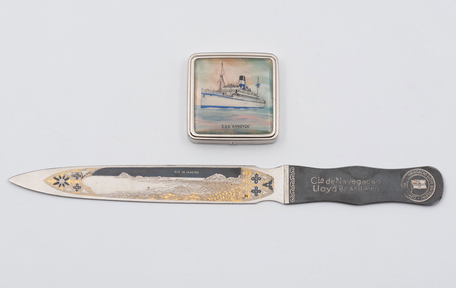 2 Brazilian Steamship Shipping Items: Includes Lloyd Brasilerio Navigation Co. letter opener. State owned Brazilian shipping company that operated from 1894-1997. Also includes TSS Vandyck Stratnoid pill box. The TS Vandyck operated from