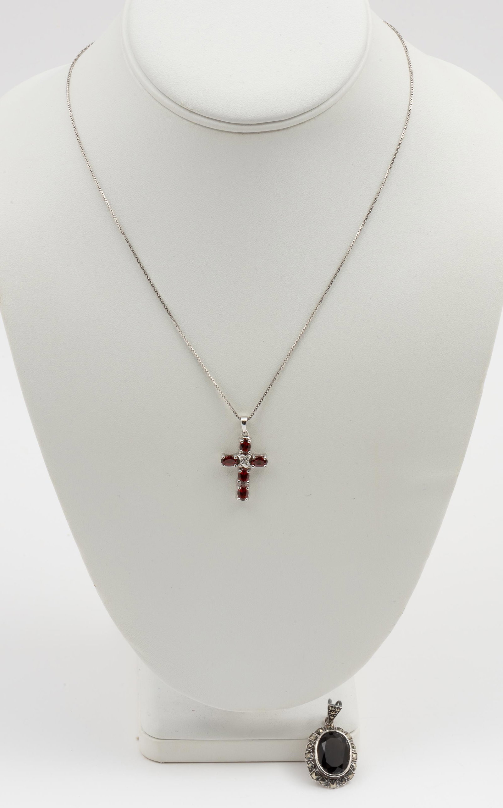 2 Sterling Pendants: Onyx and marcasite 1-3/8" high. Garnet with diamond chip 1-1/4" high on 18" chain. IMPORTANT: Before bidding, please read the terms and conditions. When you registered for the auction you agreed to th