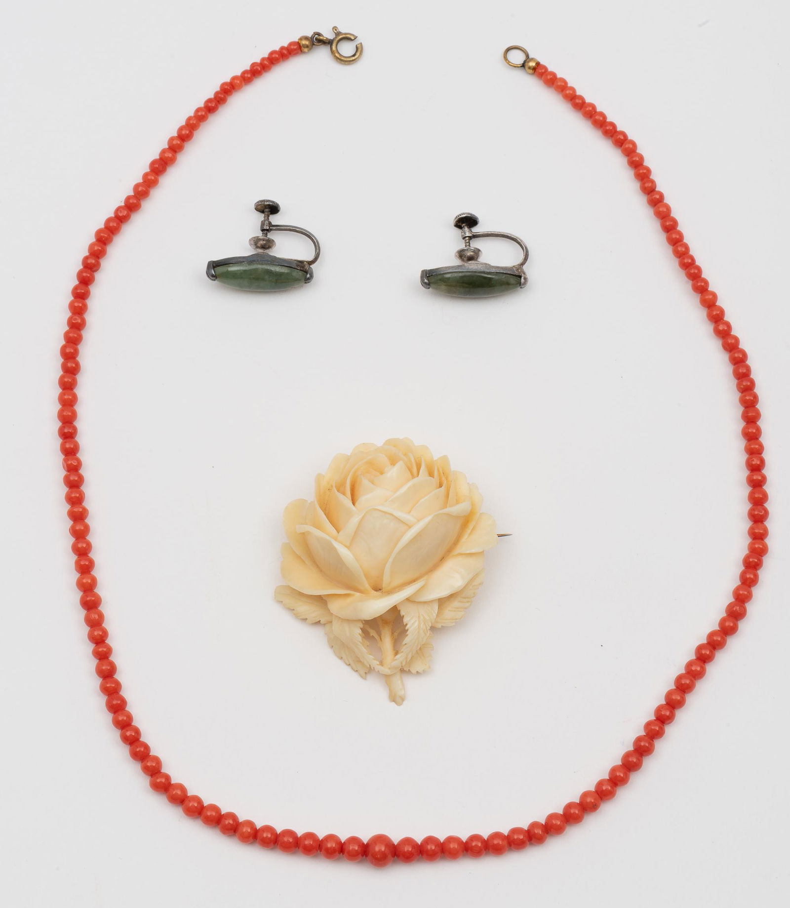 3 Pcs Vintage Jewelry: Carved bone rose brooch 1-7/8 high x 1-5/8" wide. Silver and jade screwback earrings 3/4" long. Coral graduated bead necklace 17" long. IMPORTANT: Before bidding, please read the terms and conditions.
