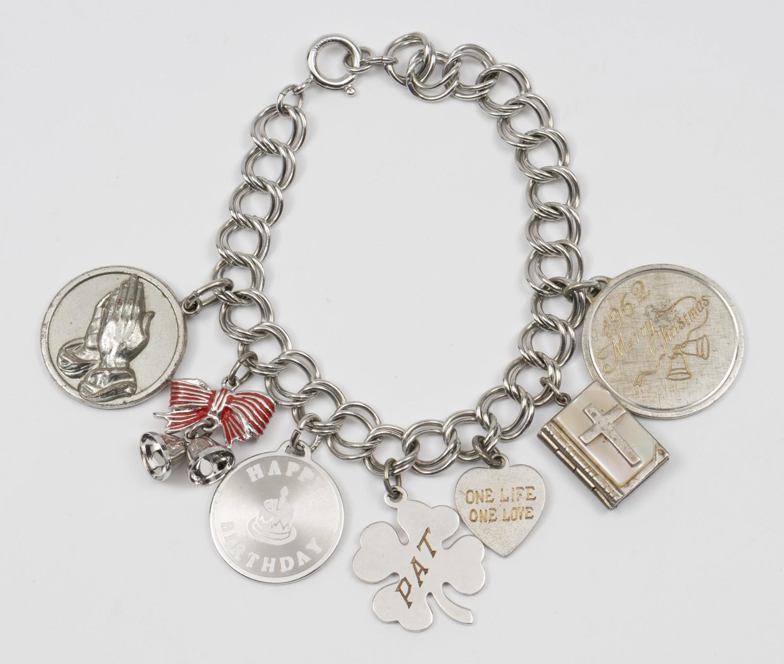 Sterling Bracelet with 7 Charms: Merry Christmas, Happy Birthday, clover, and heart charms marked sterling. Bracelet 7" long. Charms 3/4" to 1" long. MH. IMPORTANT: Before bidding, please read the terms and conditions. When you regis