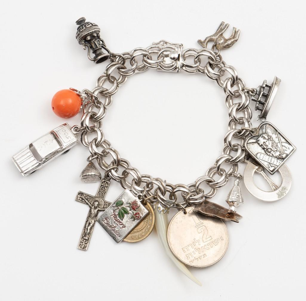 Sterling Charm Bracelet: With sterling, silver, and coin charms. 7-1/2" long. IMPORTANT: Before bidding, please read the terms and conditions. When you registered for the auction you agreed to these terms and will be required