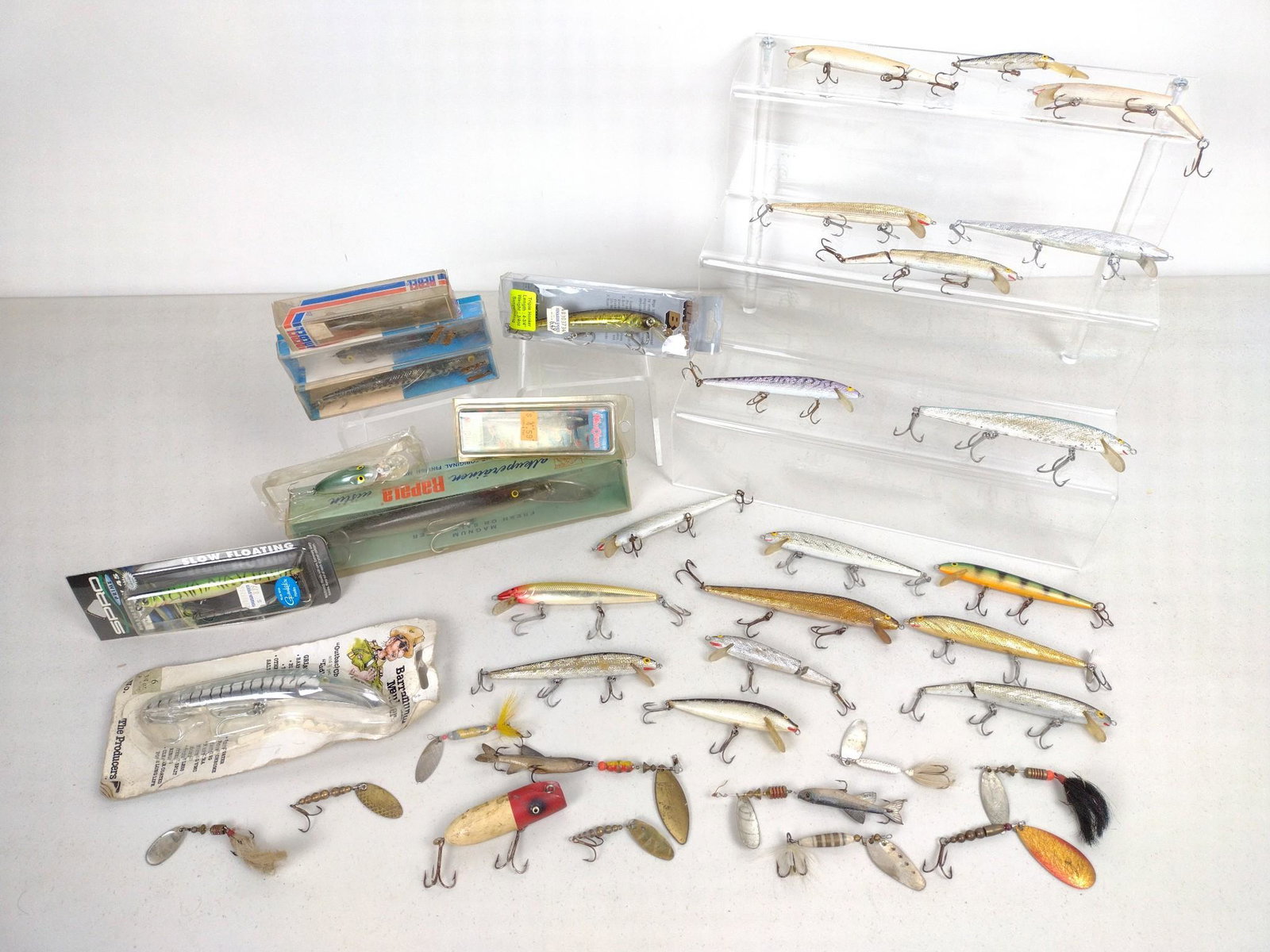 Grouping Fishing Lures incl Rapala: Also includes Rebel and Barramundi Mauler. Includes 8-1/2" Rapala Wobbler with original packaging. Also includes spinners and jigs. DM IMPORTANT: Before bidding, please read the terms and conditions. 