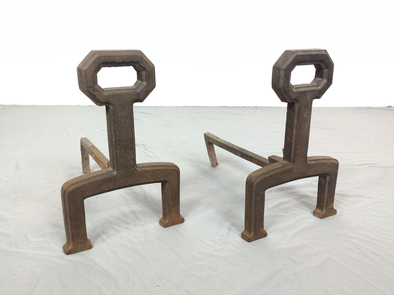 Pair of Cast Iron Andirons: 9" wide X 15" deep X 13-1/4" high. Has some discoloring. MG. IMPORTANT: Before bidding, please read the terms and conditions. When you registered for the auction you agreed to these terms and will be