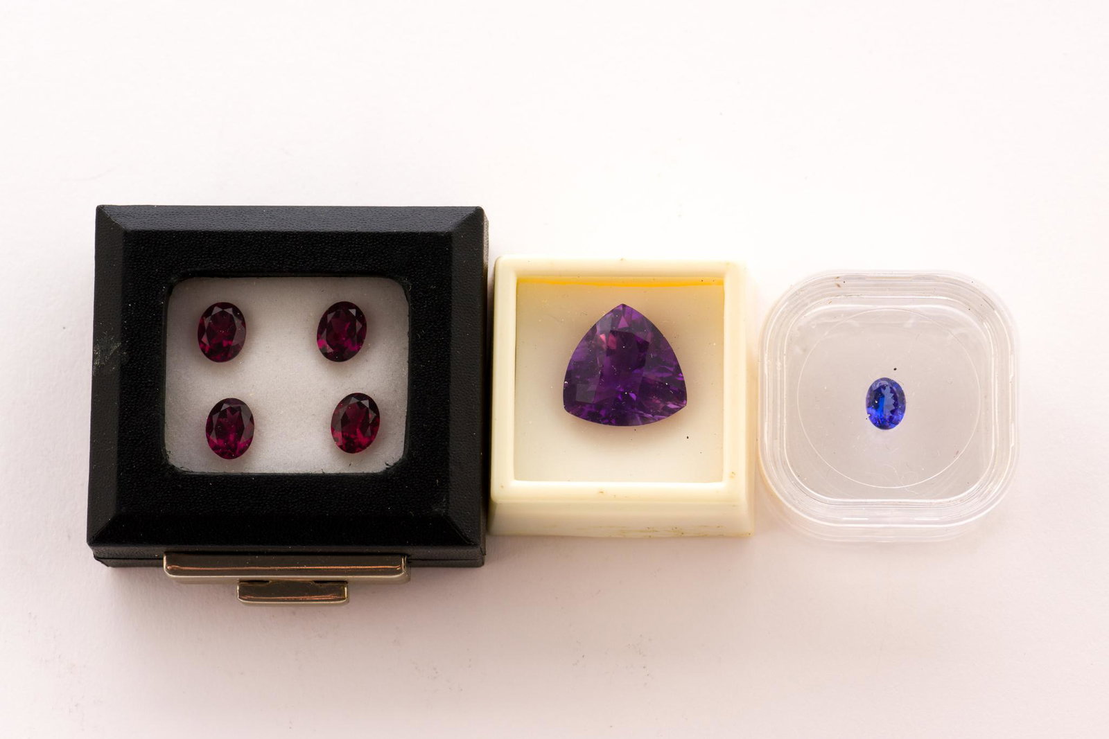 Collection of Loose Gemstones: 17 Carat trillion cut amethyst. Four oval cut Umba River rhodolite garnet (two pairs), each approximately 2.2 Carat. 2.1 Carat round Mozambique garnet. 1 Carat oval cut tanzanite. EK IMPORTANT: Before