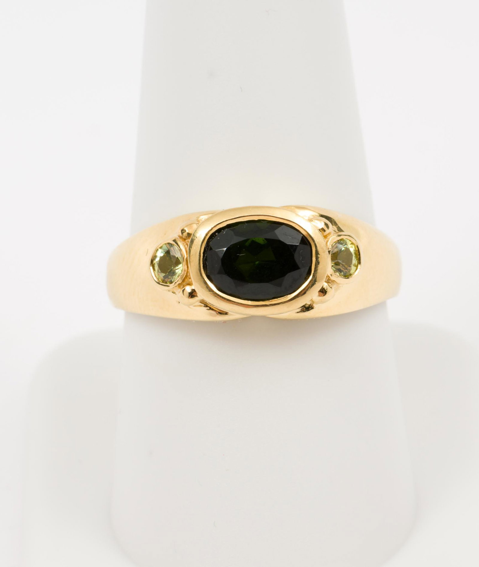 18K Tourmaline & Peridot Ring: 18k stamped setting with center oval cut tourmaline, approximately 1.15 carat, and two round peridot accents. Size 9. 3.5 dwt. RM/EK IMPORTANT: Before bidding, please read the terms and conditions. Wh