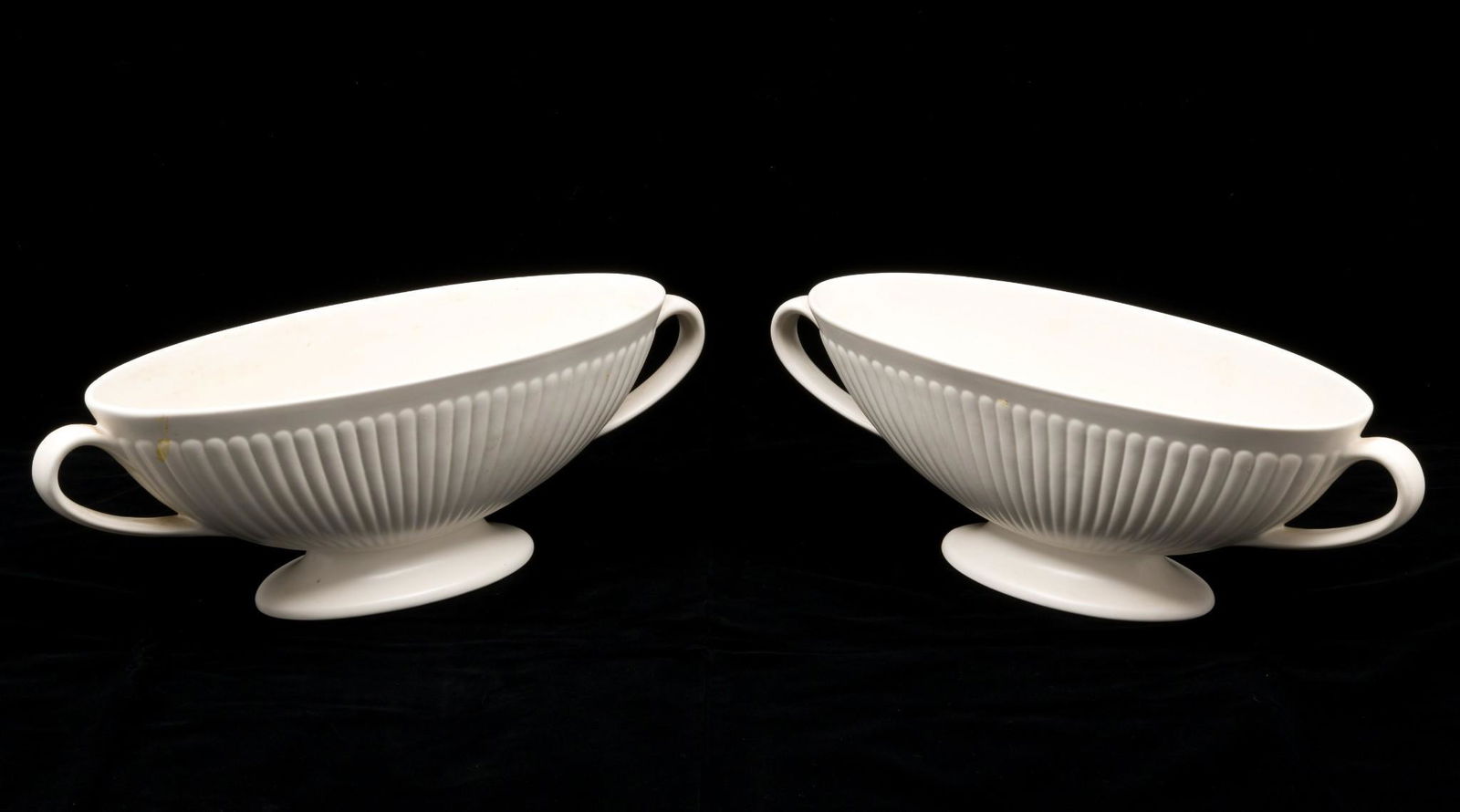 Pair of Wedgwood Oval Pedestal Centerpiece Bowls: Etruria Barlaston, Moonstone glaze. Each marked Wedgwood, made in England. Each 5" high x 15" wide. MH. IMPORTANT: Before bidding, please read the terms and conditions. When you registered for the auc
