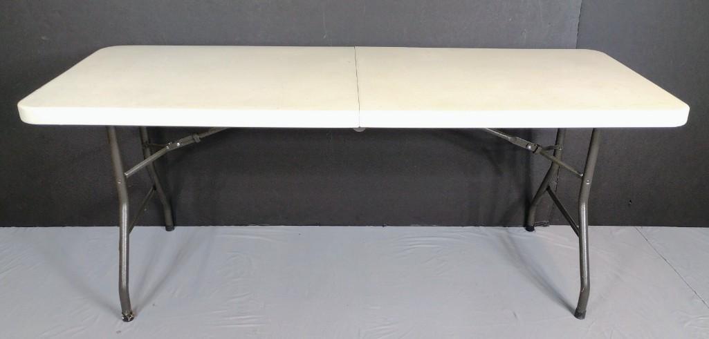 6ft Folding Table: 72" wide X 29-1/2" deep X 29" high. Top has some scratches and discoloring. MG. IMPORTANT: Before bidding, please read the terms and conditions. When you registered for the auction you agreed to these