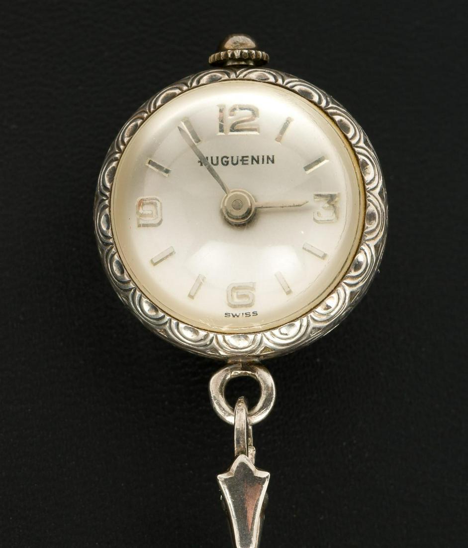 Huguenin Sterling Pendant Watch: 17J ball shaped pendant watch with clear back. Bale marked 925, chain marked 800. Watch on 28" long chain. Watch 5/8" diameter. Includes original papers and box. Runs, stops and starts. KE. IMPORTANT: