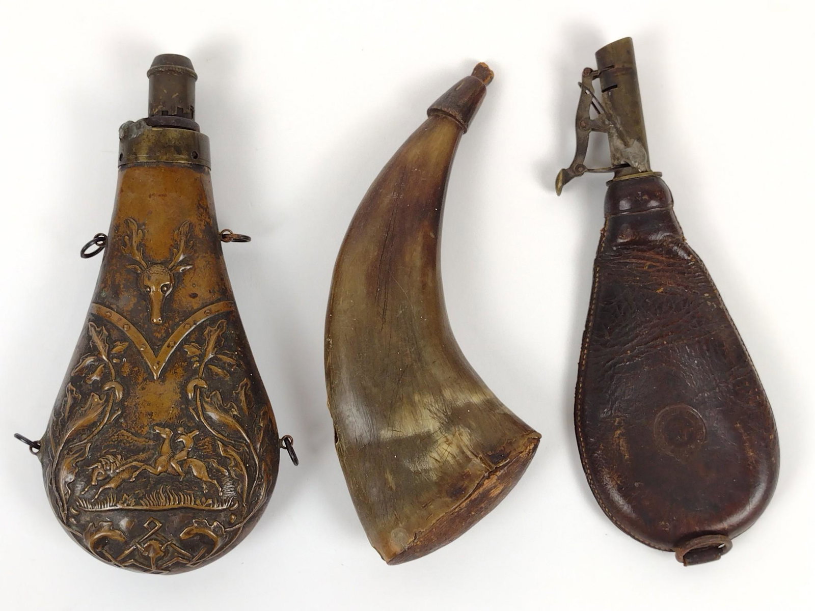 3 Powder Flasks/Horn incl Stag Scene: No makers markings. 3" to 5-1/2" wide X 4-1/2" to 8" high. DM IMPORTANT: Before bidding, please read the terms and conditions. When you registered for the auction you agreed to these terms and will be