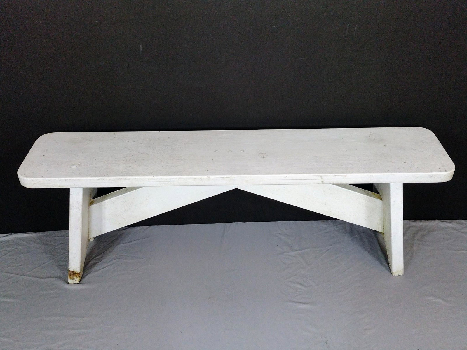 White Painted Bench: 55" wide X 11" deep X 19" high. Has discoloring. MG. IMPORTANT: Before bidding, please read the terms and conditions. When you registered for the auction you agreed to these terms and will be required
