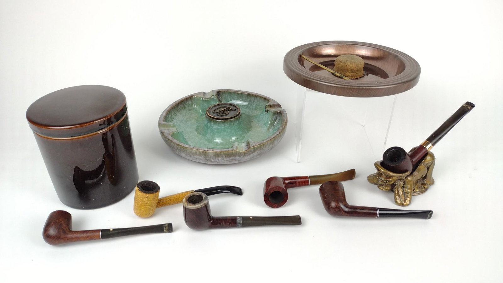 10 Pipes, Ash Trays, and Tobacco Cannister: Cannister marked "Savory's Italy." One ash tray marked "The Hyde Park No. 1900." Ash Trays: 7-3/4" to 8-1/4" diameter. Cannister: 5" high. DM IMPORTANT: Before bidding, please read the terms and condi