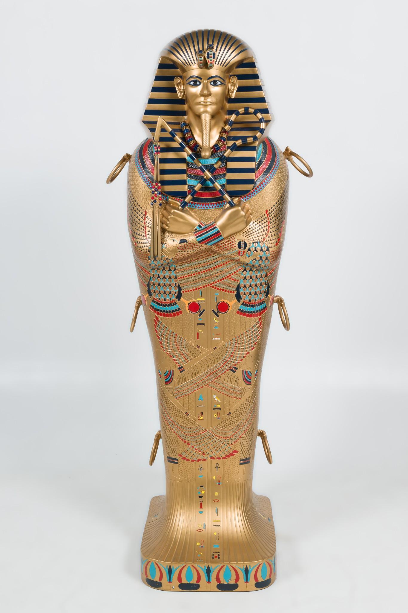 King Tut Sarcophagus w/ Faux Mummy: DESCRIPTION: King Tut sarcophagus with faux mummy. Satin interior and decoration mimics modern day casket. Faux 6' tall mummy comes out when sarcophagus opens. MEASUREMENTS: 22" wide x 24" deep x 76" 