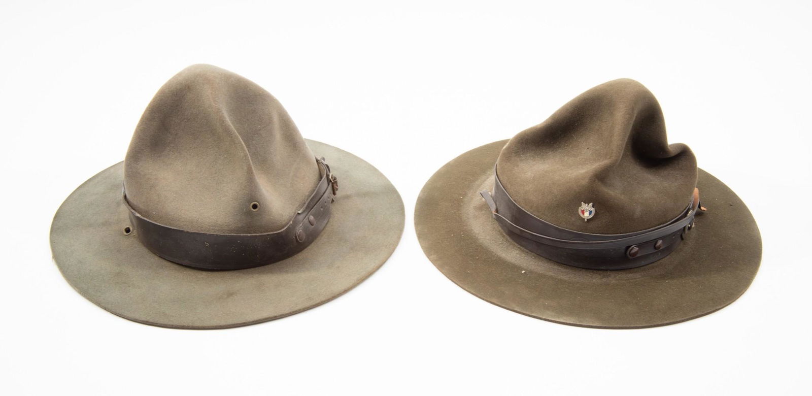 2 Boy Scouts of America Campaign Hats: Both hats green suede with brown leather band stamped with BSA logo. One also with BSA pin. Both with brown leather interior liner. One marked with name Collins to interior. 12-7/8" wide x 12-3/4" lon