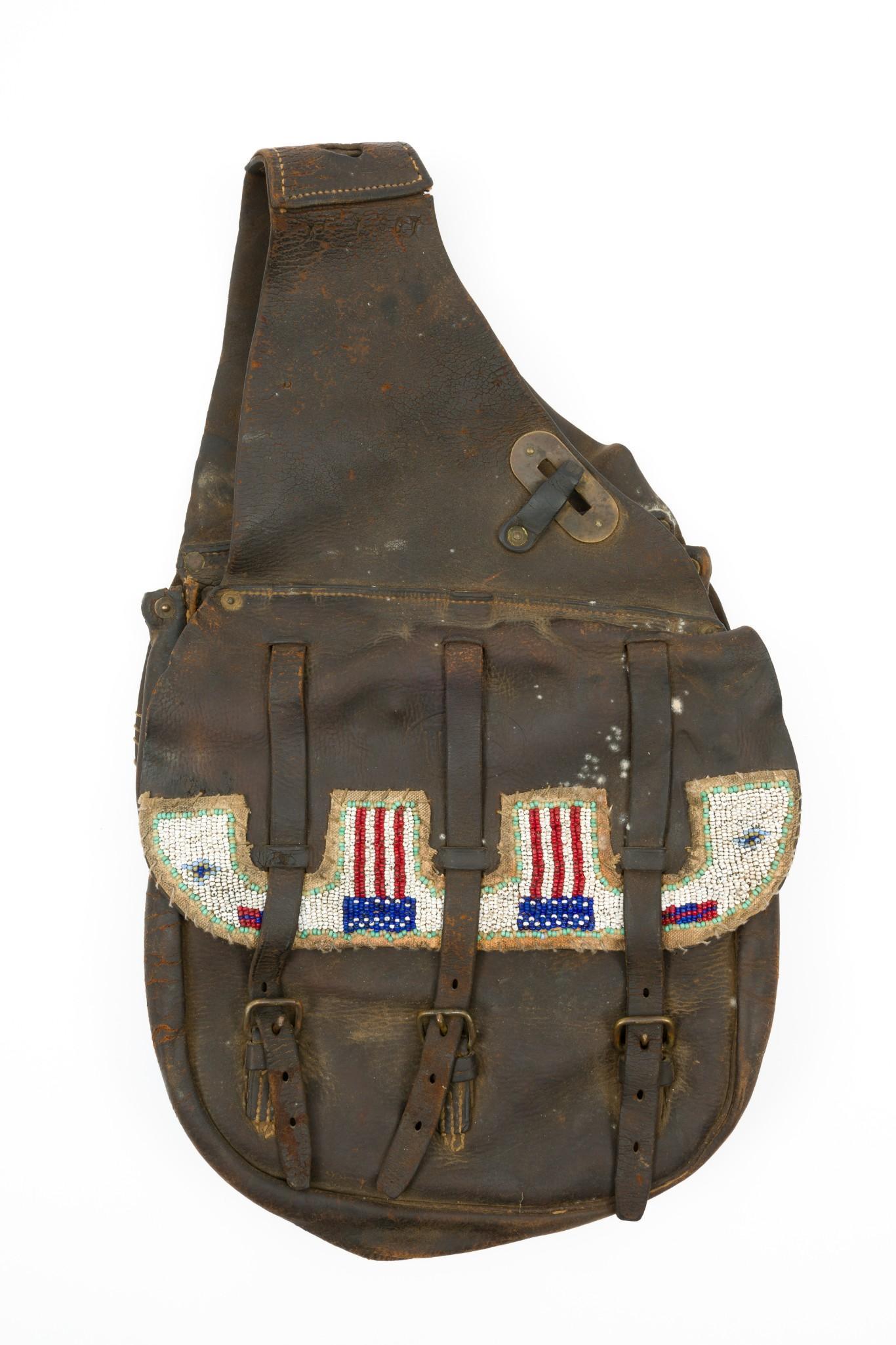 Western Saddle Bag: Mid 20th century. A shaped flag pattern lazy stitch beaded panel has been added to the flaps. 19" long x 11-1/2" wide. RM IMPORTANT: Before bidding, please read the terms and conditions. When you regi