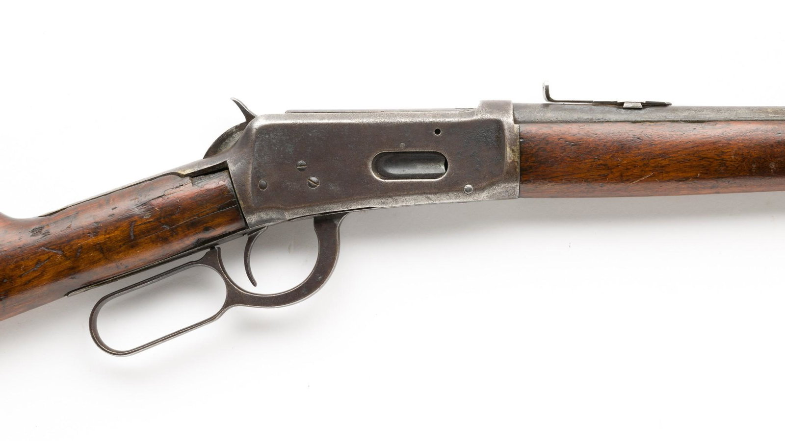 Early Winchester Model 1894 Carbine, Caliber .30 WCF: Serial Number: 475163 Design: Winchester manufactured in 1909. 20" round barrel, chambered for the .30 WCF cartridge. Leaf rear sight. Steel butt plate. With antique leather scabbard. Condition: Fair.
