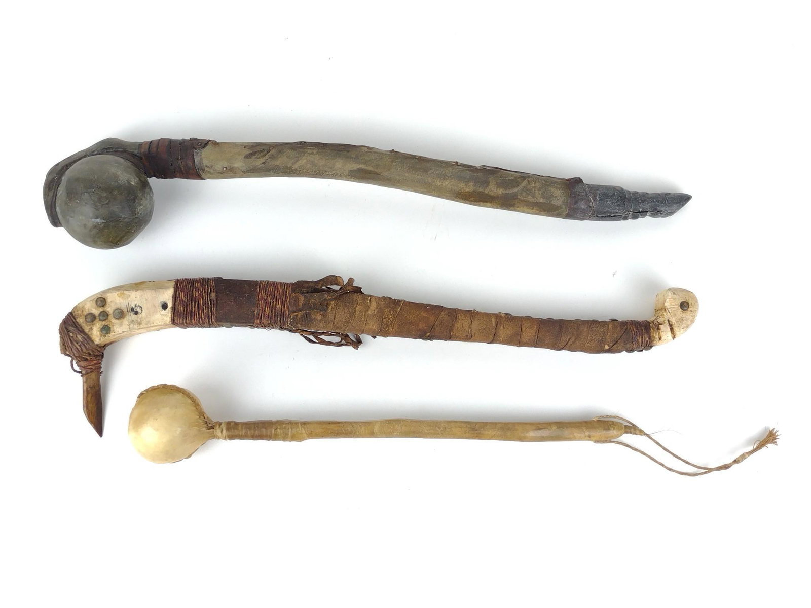 3 Native American War Clubs: Stone, wood, and rawhide. 17-1/2" to 23-1/4" long. DP. IMPORTANT: Before bidding, please read the terms and conditions. When you registered for the auction you agreed to these terms and will be requir