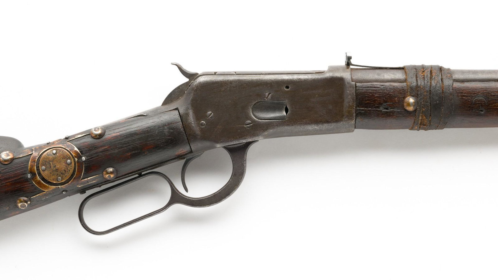 Relic Condition Winchester Model 1892 Carbine, Caliber .44: Serial Number: NSN Design: Winchester 1892 carbine, cal. .44, is heavily rusted and worn throughout. Markings worn beyond legibility and wood has cracks; forend partially held fast with rawhide. Rawhi
