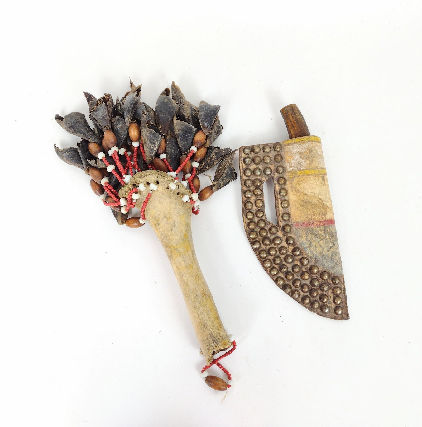 Native American Elk Handled Knife & Bone Rattle: Includes elk handled knife in a studded leather sheath, circa 19th and 20th centuries, 8-3/4" long out of sheath, 11-1/4" long x 4-1/2" wide in sheath. Bone rattle with attached bear claws and beading