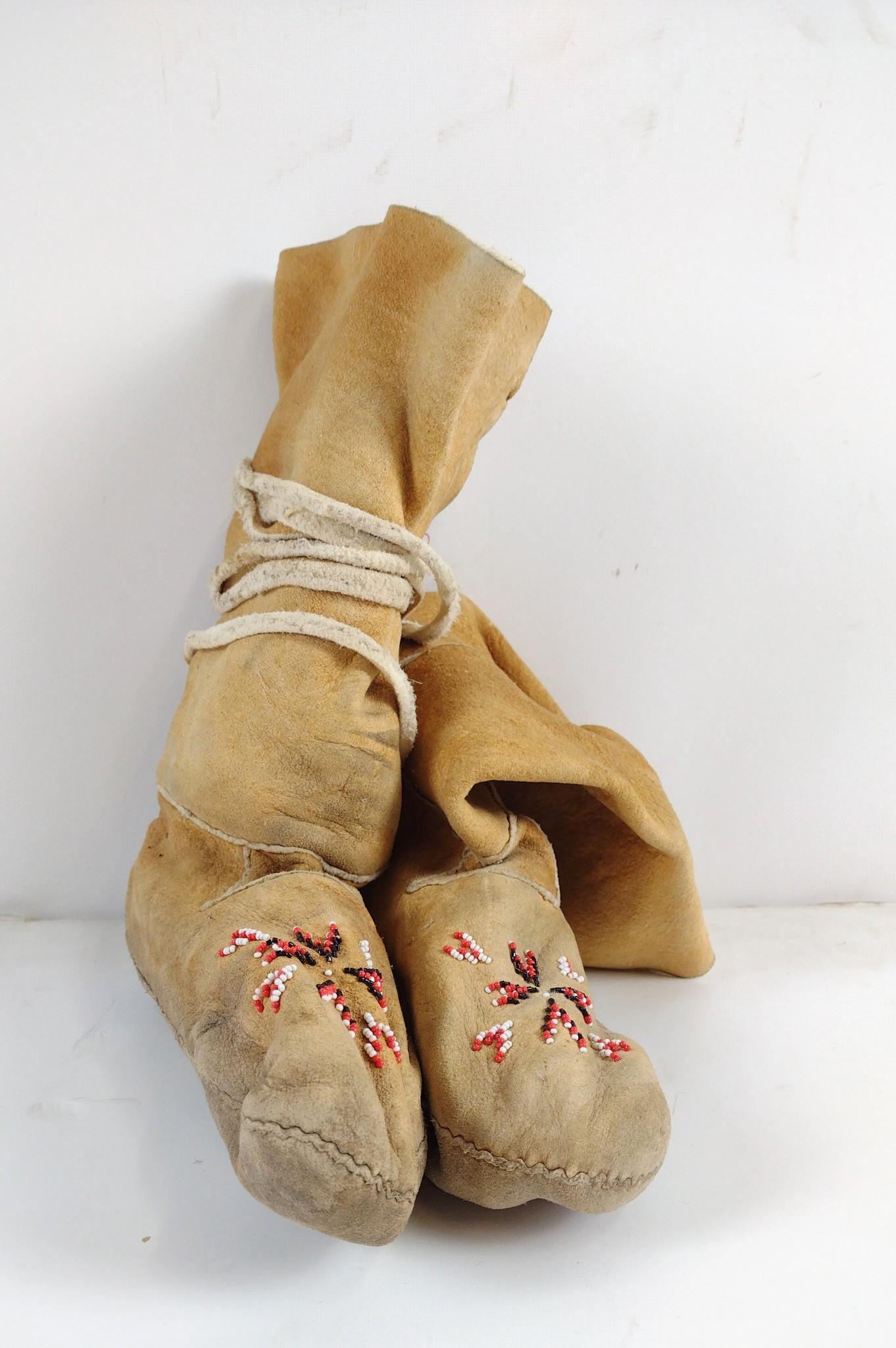 Pair of Plains Indian Moccasins: Constructed of hide with simple lazy stitch beading. Circa second half of the 20th century. 9-1/2" long x 3" wide x 12" high. IMPORTANT: Before bidding, please read the terms and conditions. When you 